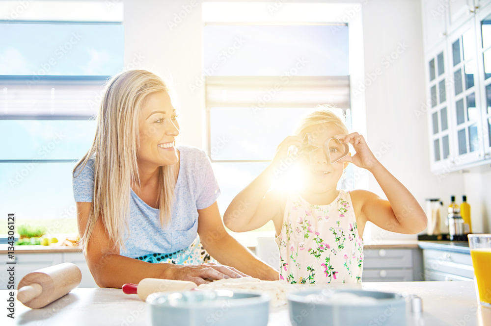 Playful little girl holding cookie cutters