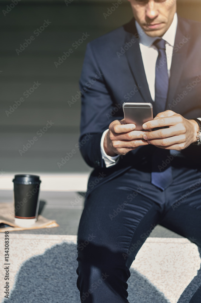 Working with smartphone man wearing stylish suit