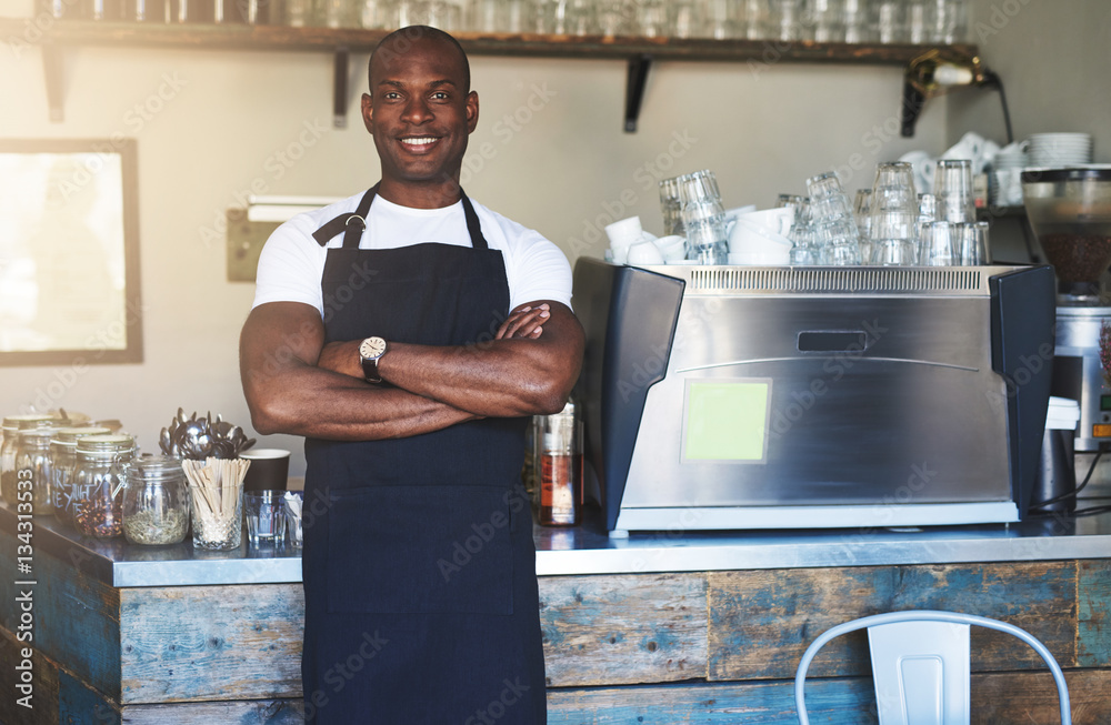 Smiling black male worker posing in cafe