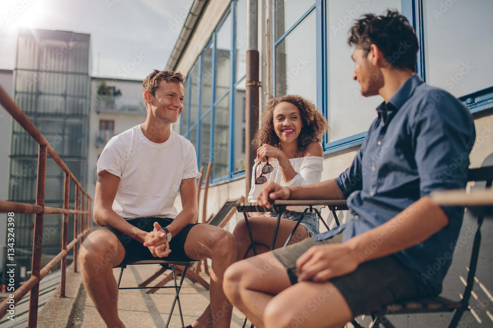 Three young friends together at outdoor cafe