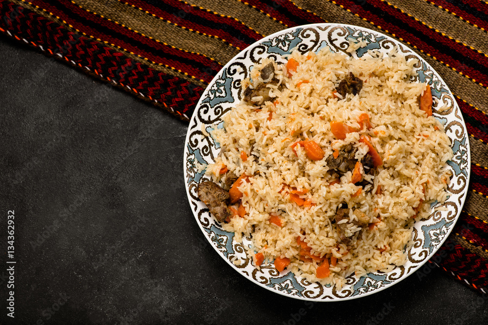 Pilaf on plate with oriental ornament. Central-Asian cuisine - Plov. Top view.