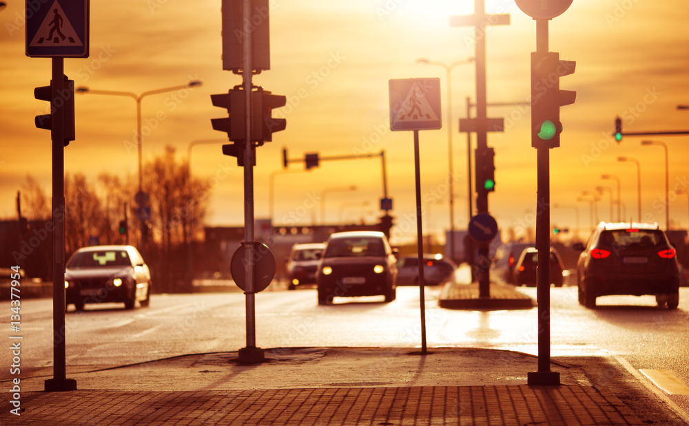 Cars moving on the road in city in early morning. View to the traffic with trafficlights and transpo