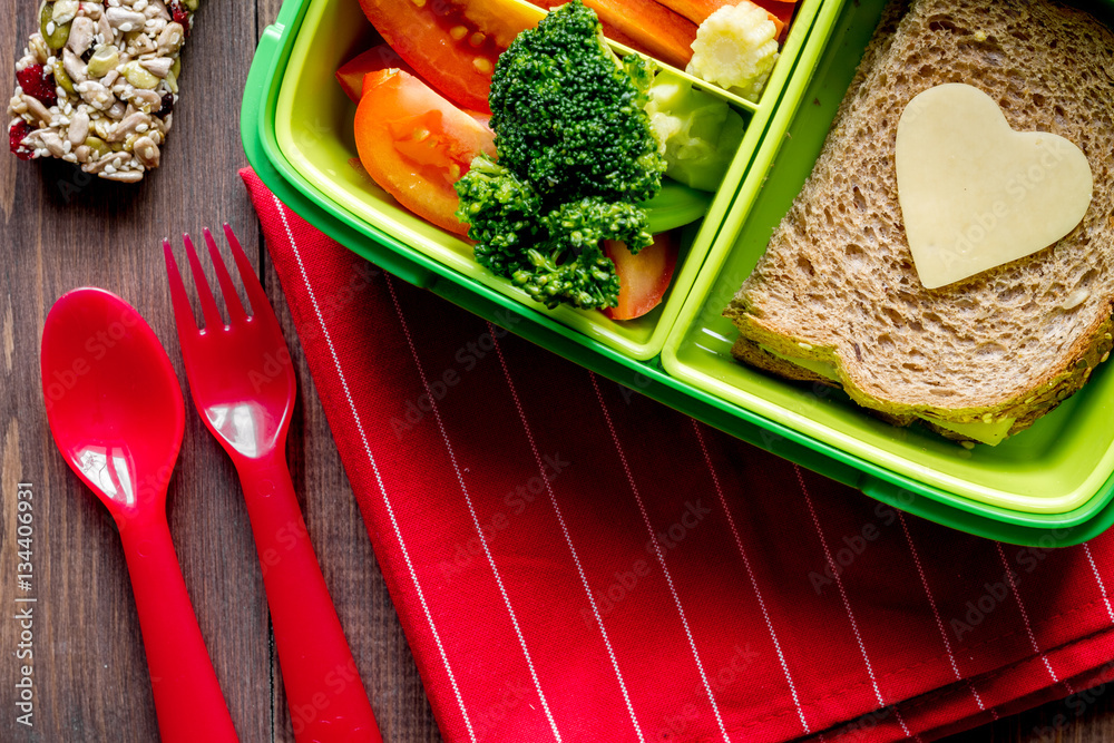 green lunch box for kid on wooden background top view