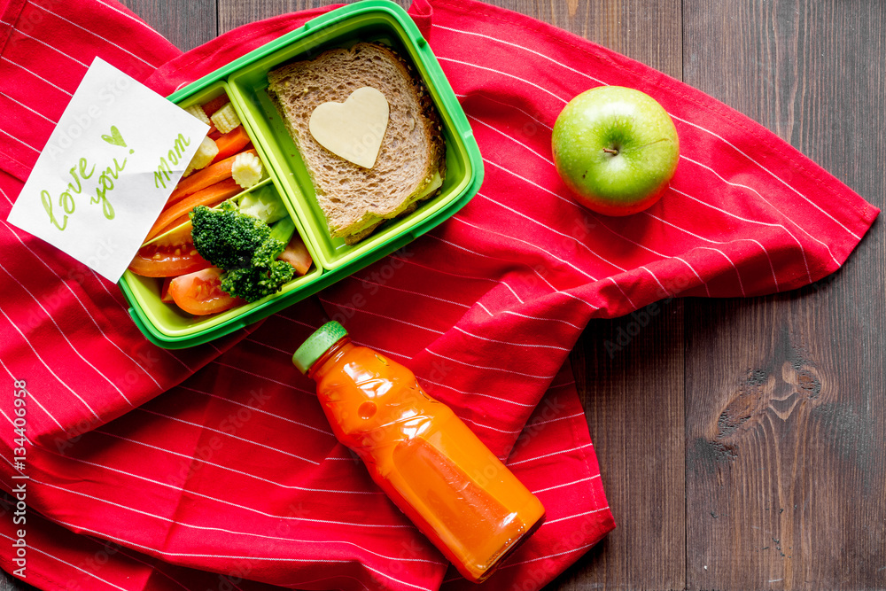 green lunch box for kid on wooden background top view