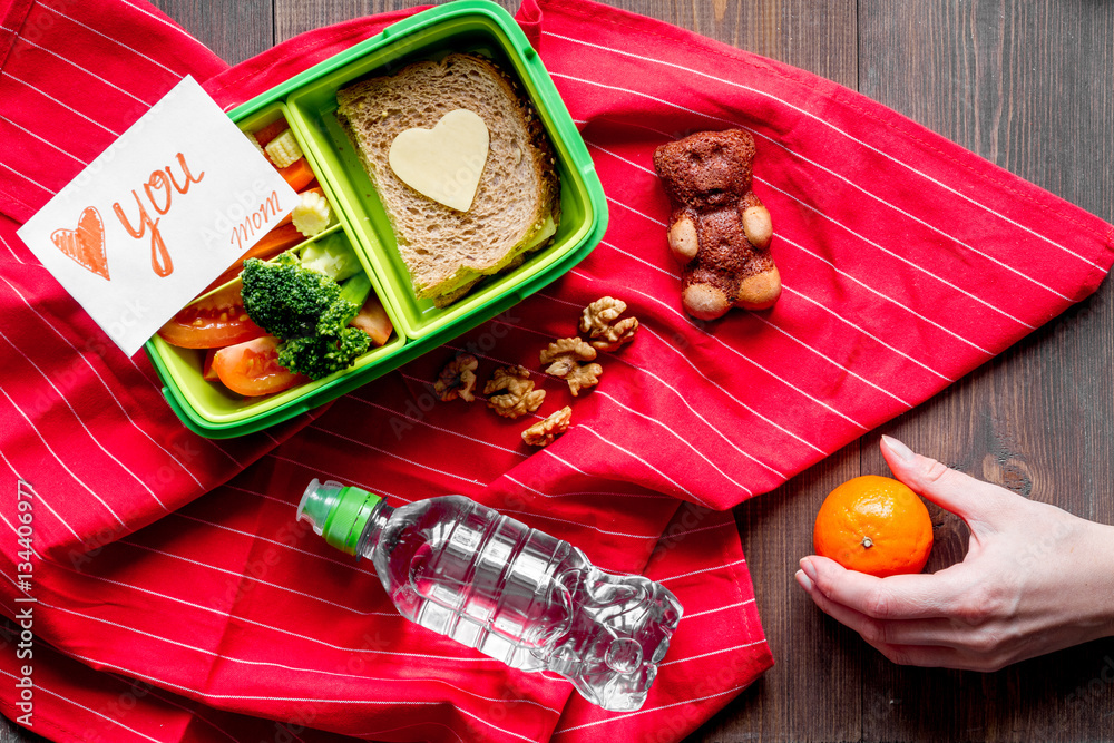 green lunch box for kid on wooden background top view