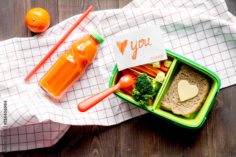 green lunch box for kid on wooden background top view