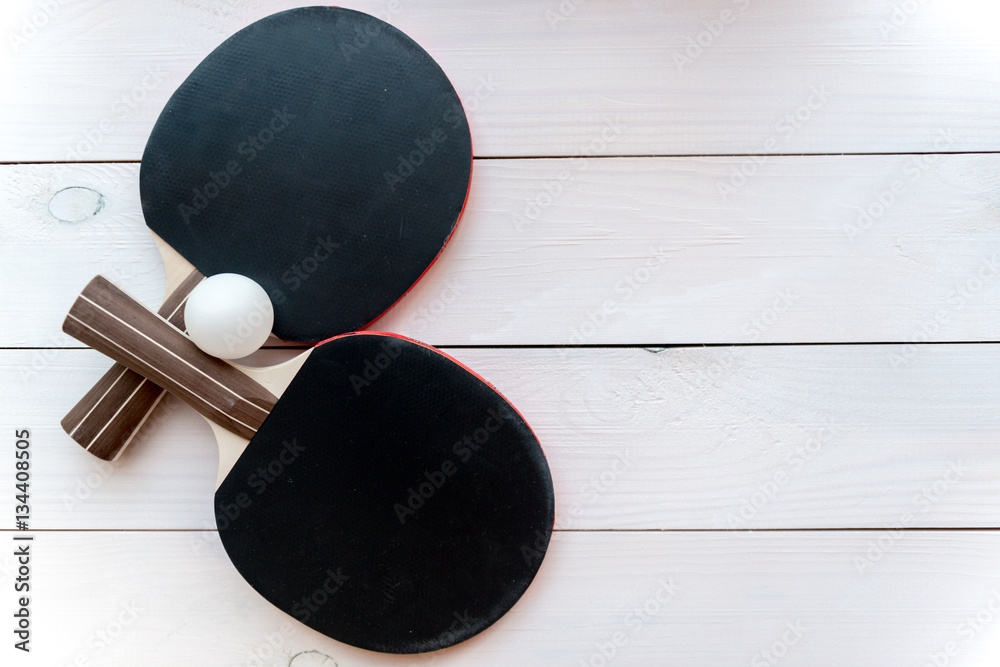 black racket for ping pong ball wooden background top view