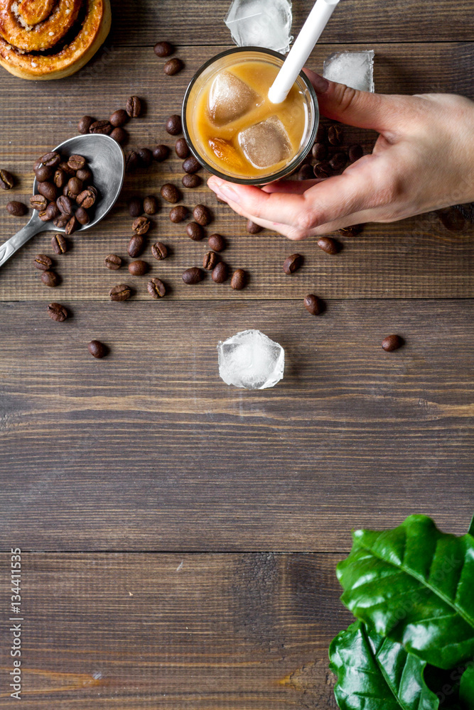 coffee with ice in glass on wooden background top view