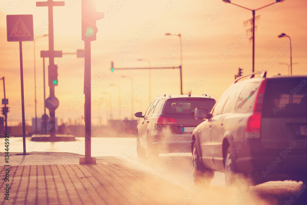 Cars moving on the road in city in early morning. View to the traffic with trafficlights and transpo