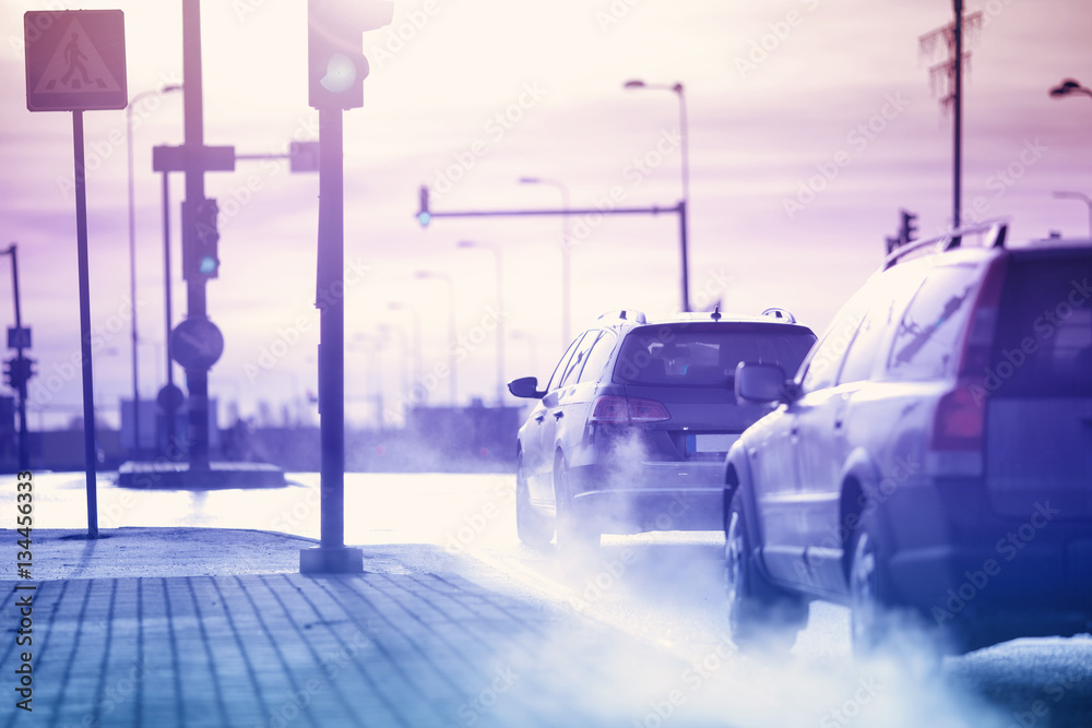 Cars moving on the road in city in early morning. View to the traffic with trafficlights and transpo