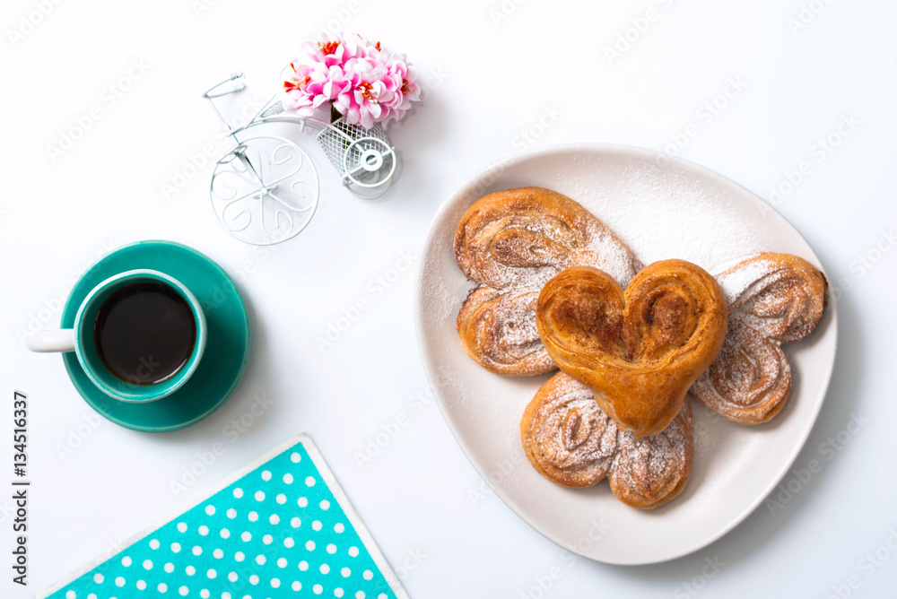 Buns with cinnamon and powdered sugar and a cup of coffee and a