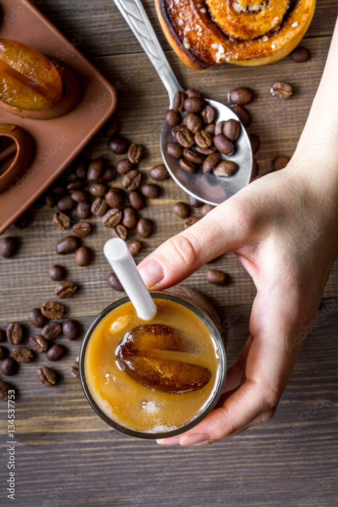 coffee with ice in glass on wooden background top view