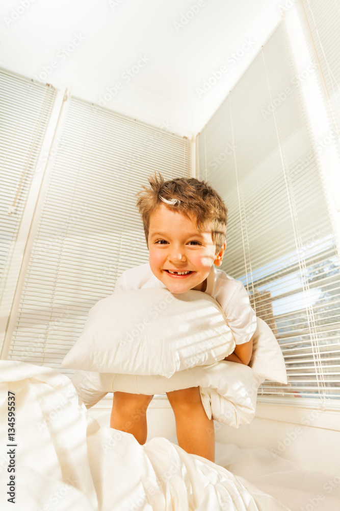 Portrait of cute kid boy having fun in his bedroom