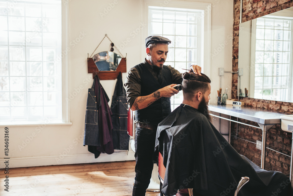 Male barber giving client haircut