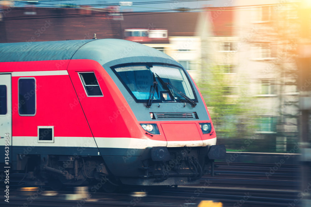 High speed passenger train on tracks in motion at sunset. Commuter train. Railway station in Nurembe