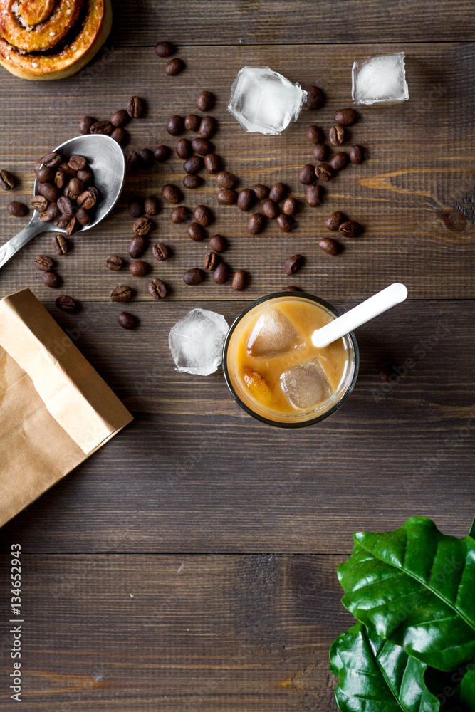 coffee with ice in glass on wooden background top view