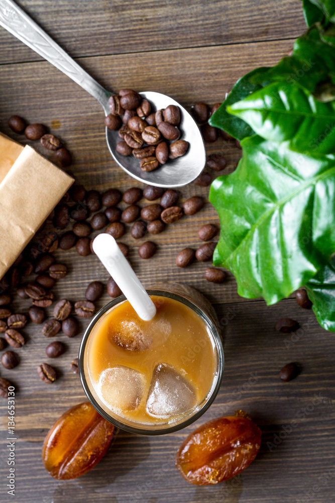 coffee with ice in glass on wooden background top view