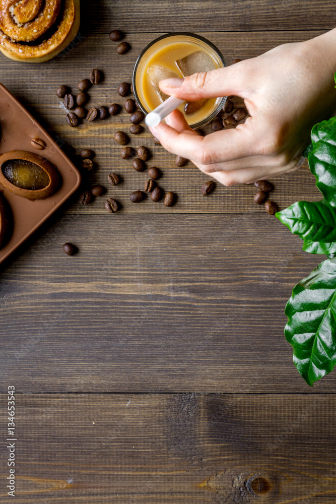 coffee with ice in glass on wooden background top view