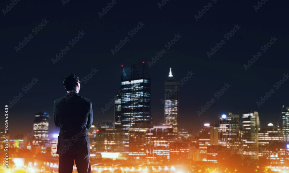 Businessman viewing night glowing city