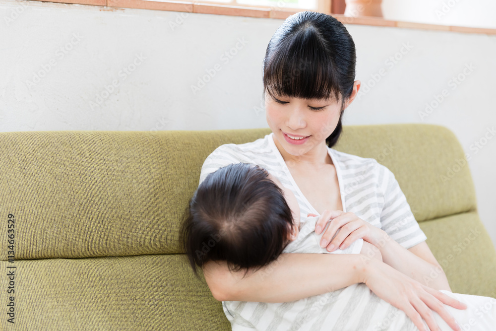 asian mother and baby relaxing on the sofa