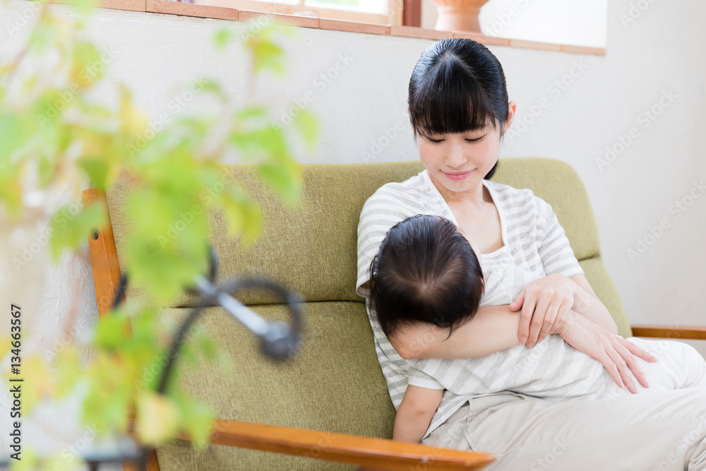 asian mother and baby relaxing on the sofa