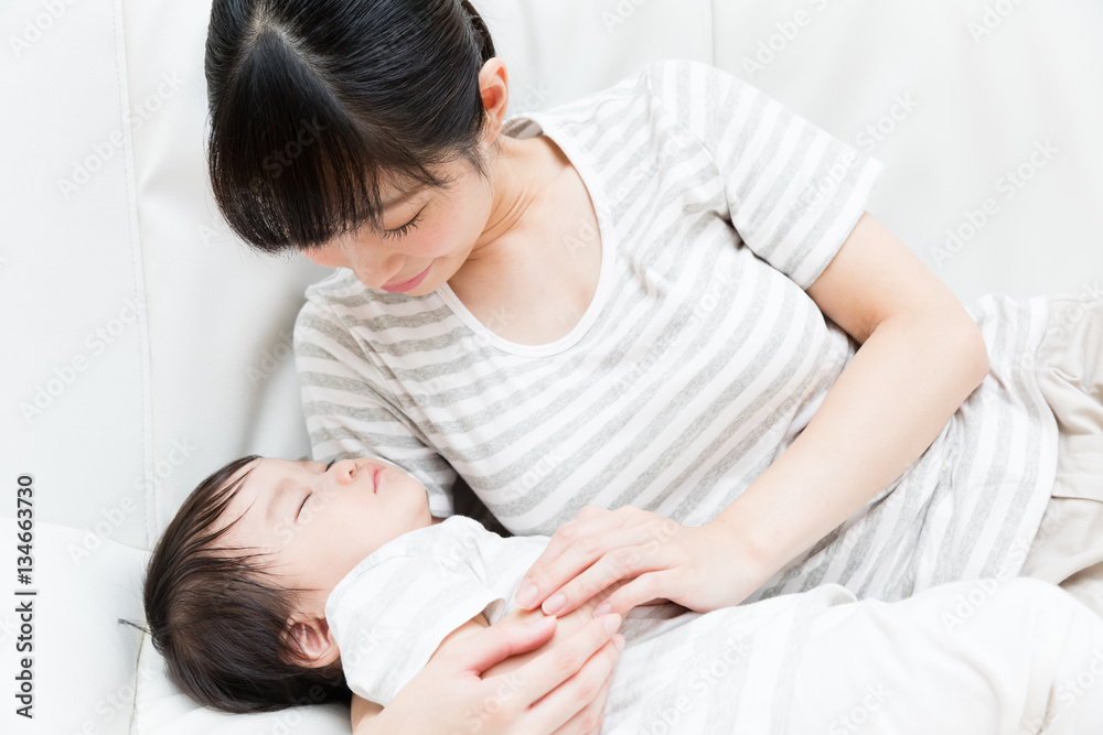 asian mother and baby relaxing on the sofa