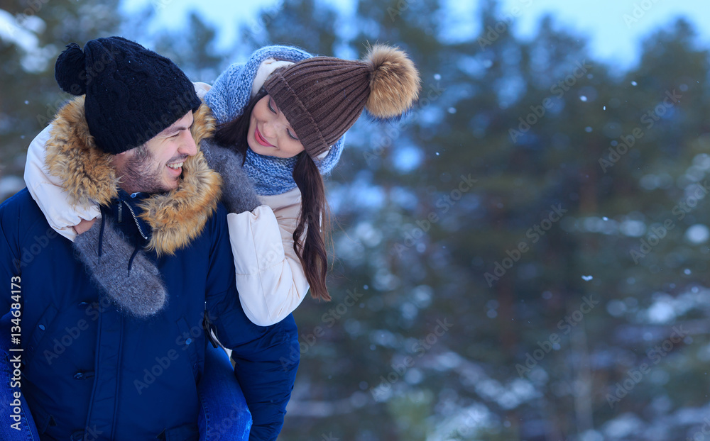 Playful smiling couple walking in winter forest