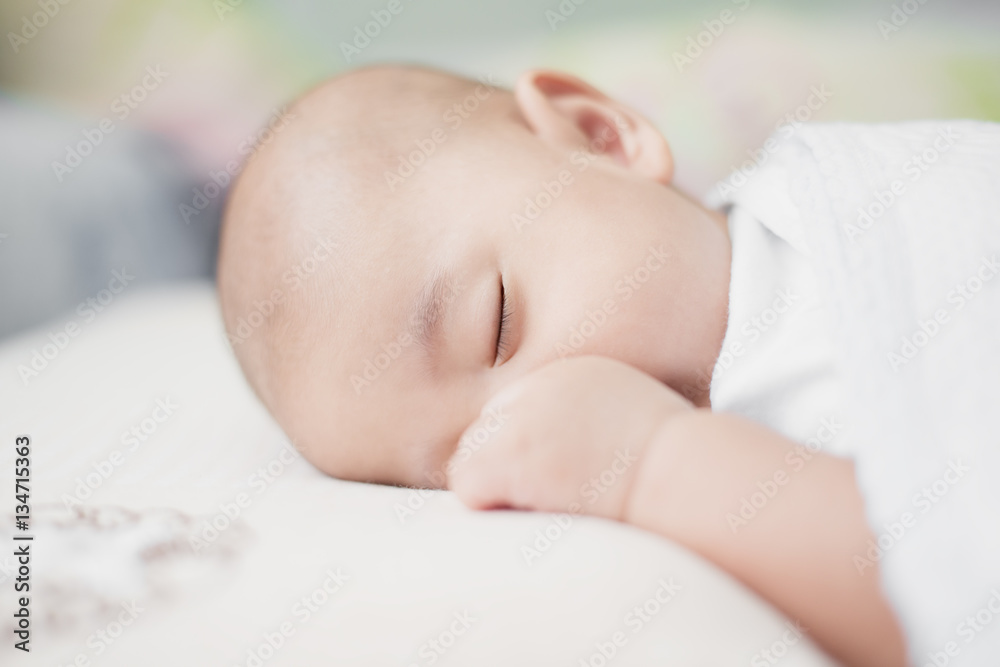 Asian little infant baby boy sleeping on soft white blanket in b