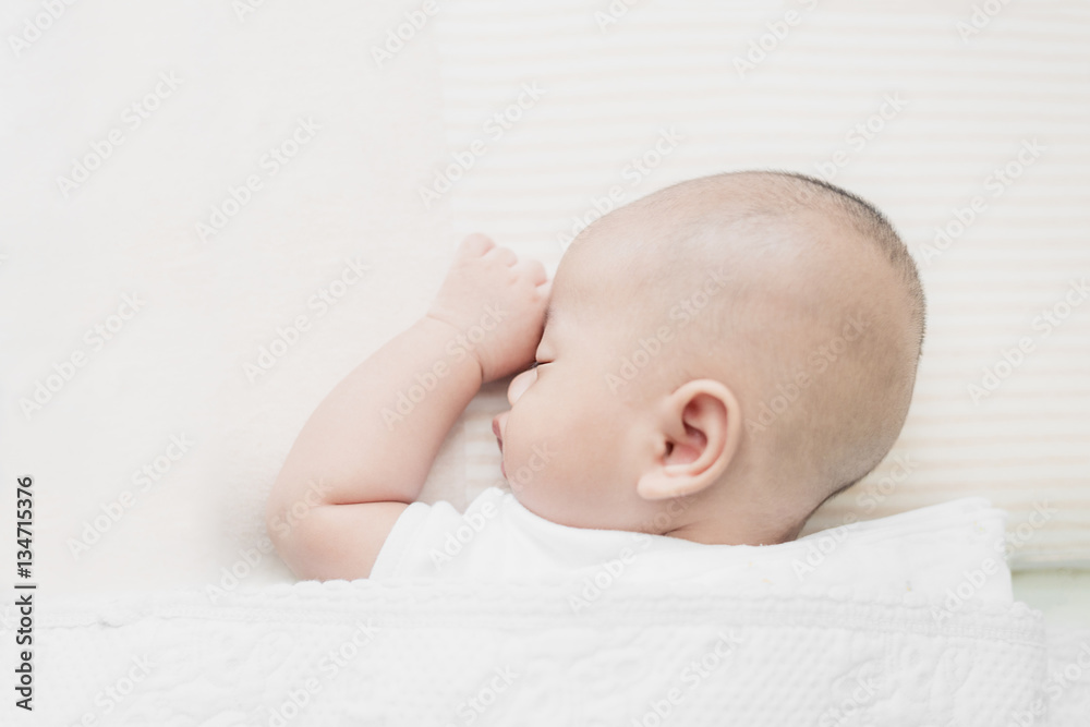 Asian little infant baby boy sleeping on soft white blanket in b