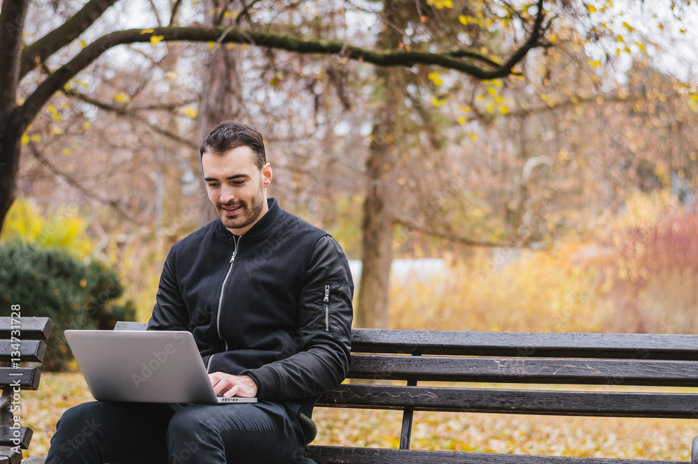 College student with computer in the park