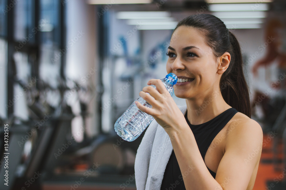 Profile of beautiful woman going to drink some water from plasti