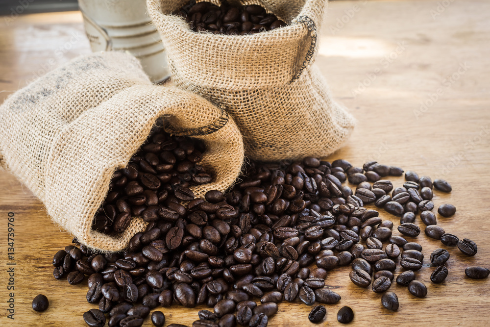 The sack of coffee beans on wooden background