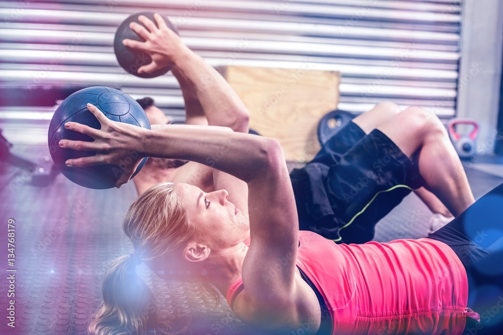 Fit couple doing abdominal ball exercise