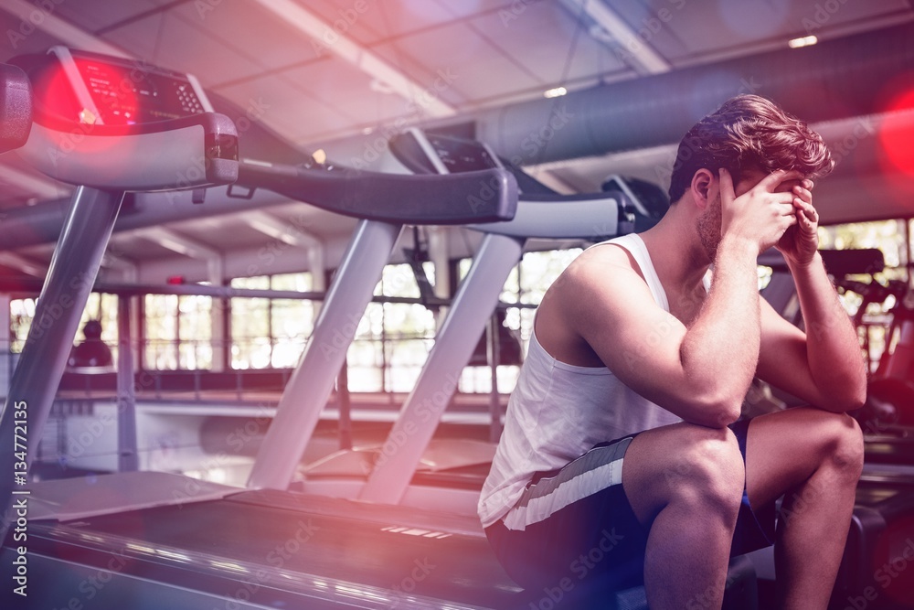 Tired man sitting on treadmill