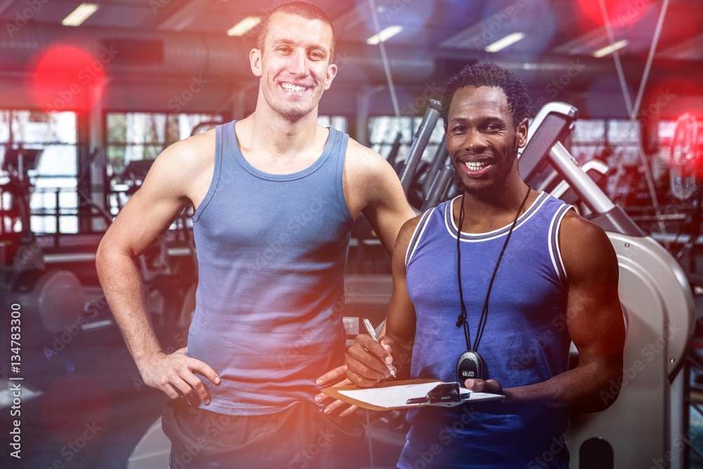 Muscular man with trainer smiling at camera 