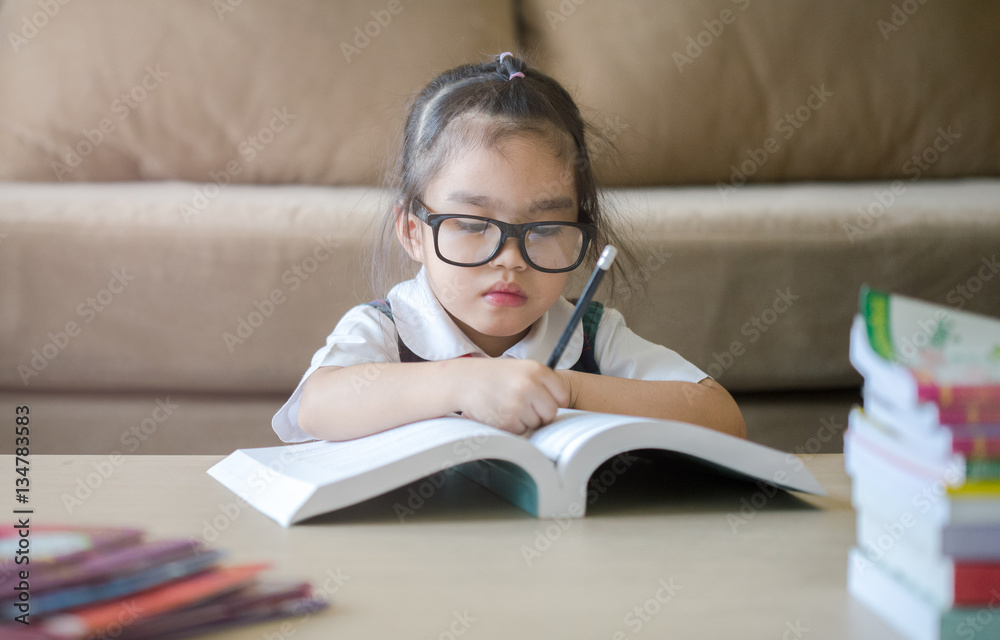 Asian little girl draw on a book