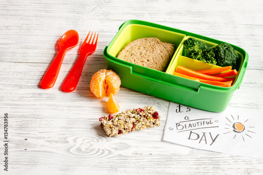 lunch box for kid with fresh vegetables on wooden background