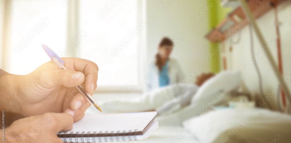 Composite image of close up of man writing in notepad