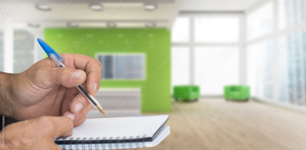 Composite image of close up of man writing in notepad