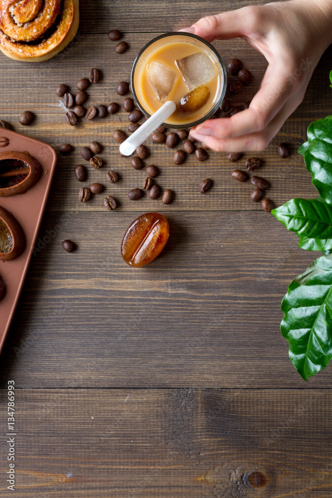 coffee with ice in glass on wooden background top view