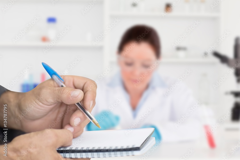 Composite image of close up of man writing in notepad