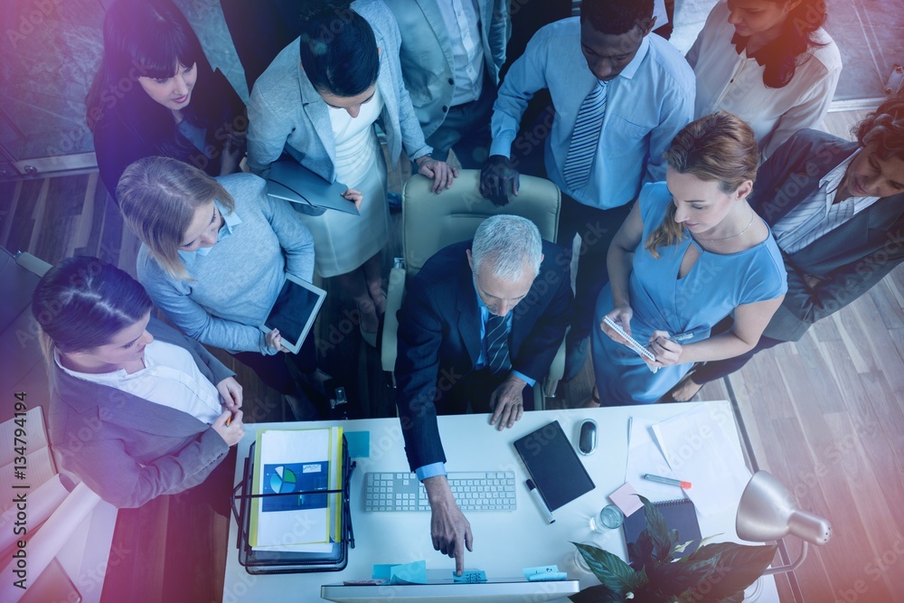 Businessman discussing with colleagues over computer