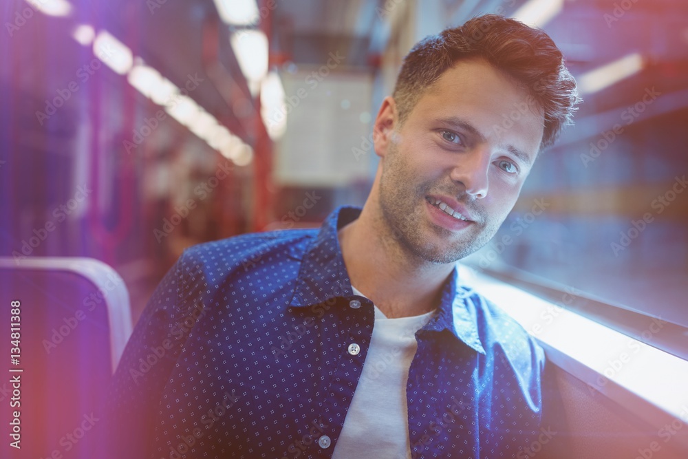 Portrait of man sitting by window in train