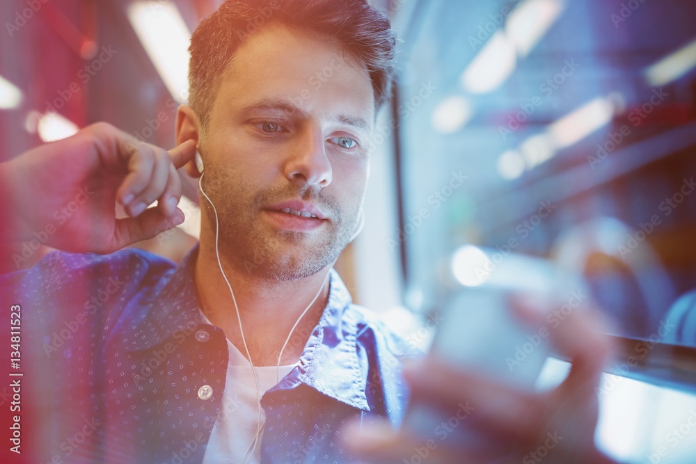 Close up of man listening music on mobile phone