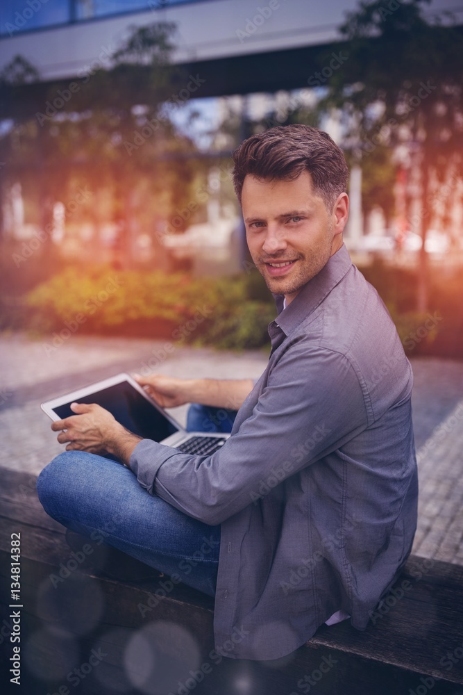 Portrait of handsome business executive using laptop