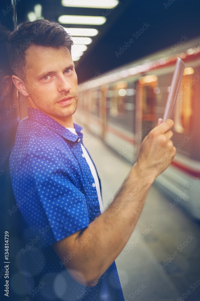 Portrait of handsome man using digital tablet