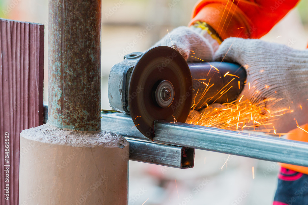 man cutting steel with electric grinder tool