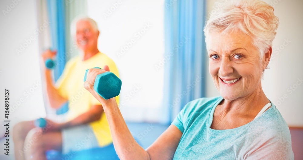 Seniors using exercise ball and weights