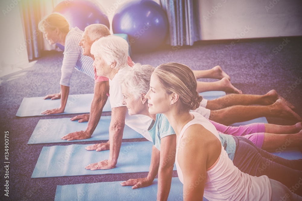 Seniors and fitness instructor stretching their legs