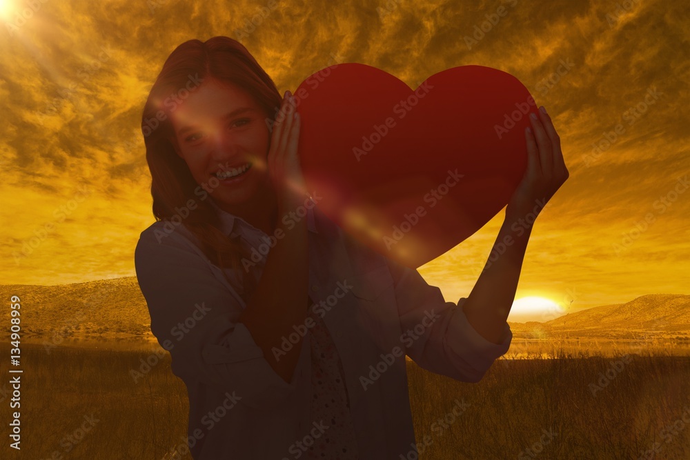 Composite image of woman holding heart card 